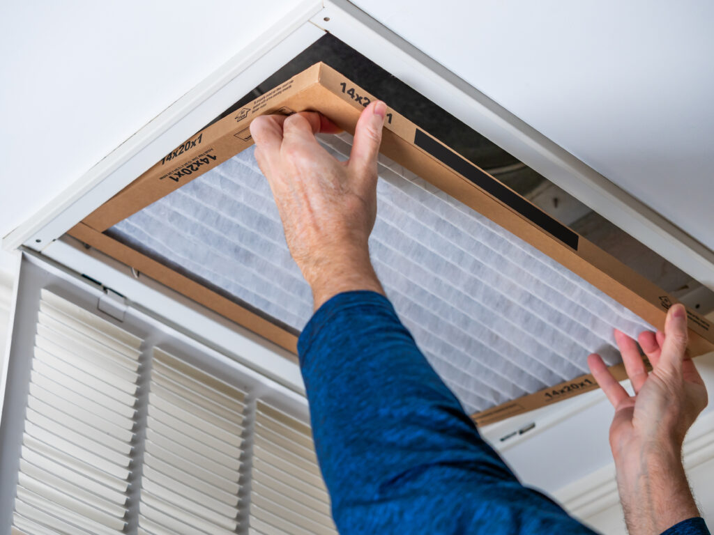 HVAC technician replacing a home air filter in San Rafael