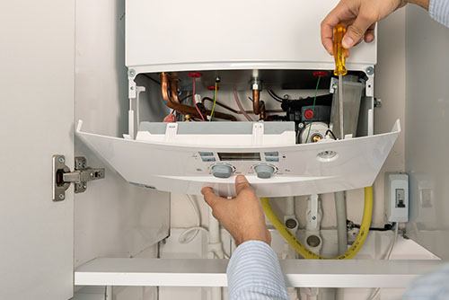 Heating technician repairing a residential boiler in San Rafael