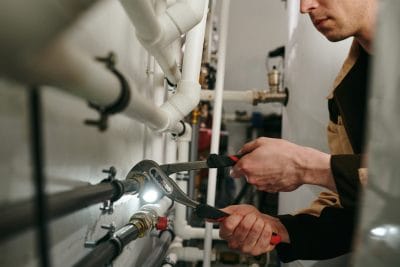 Technician inspecting commercial plumbing pipes in San Rafael